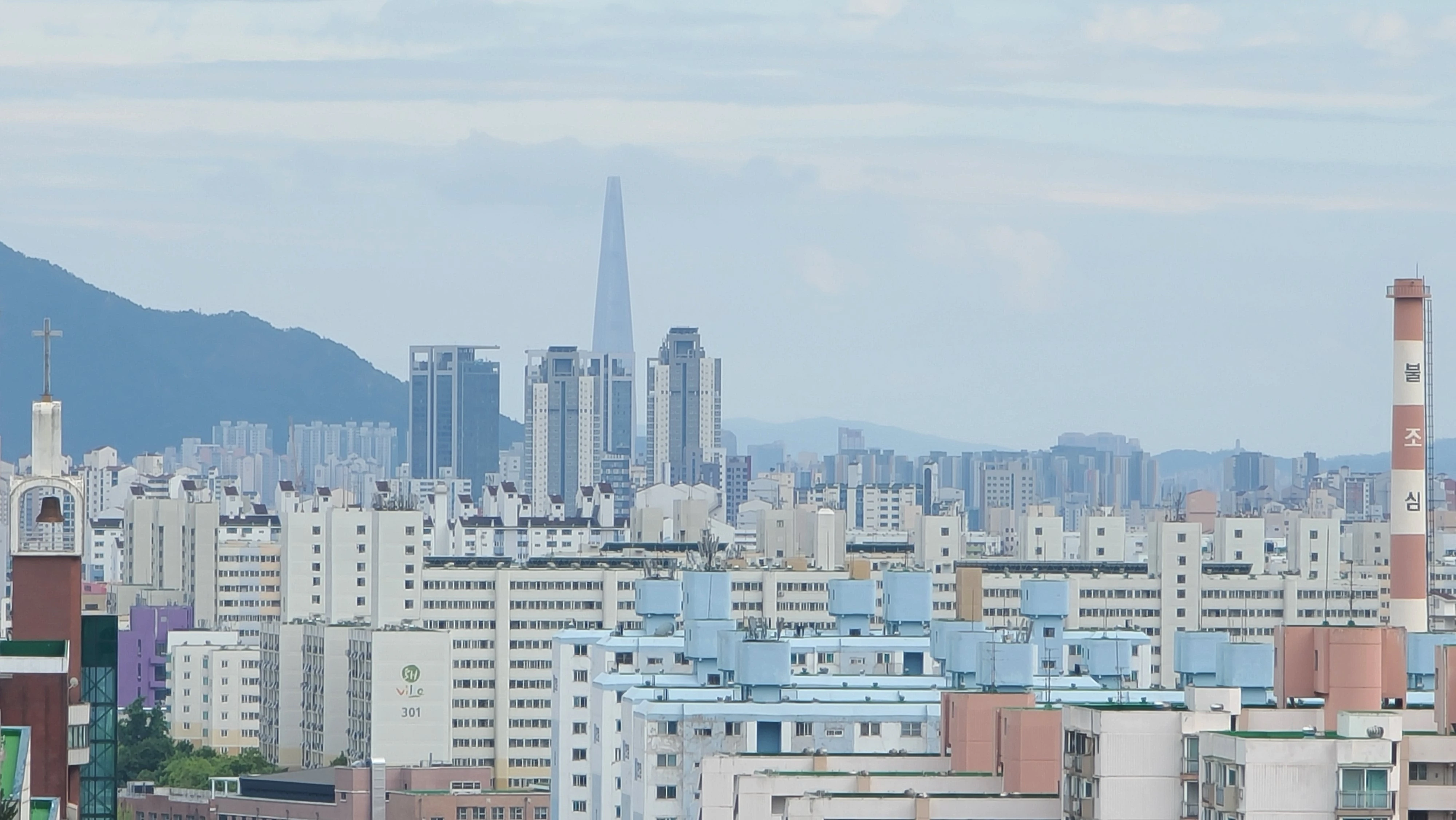 서울 노원구의 고층 아파트 단지와 멀리 보이는 롯데월드타워